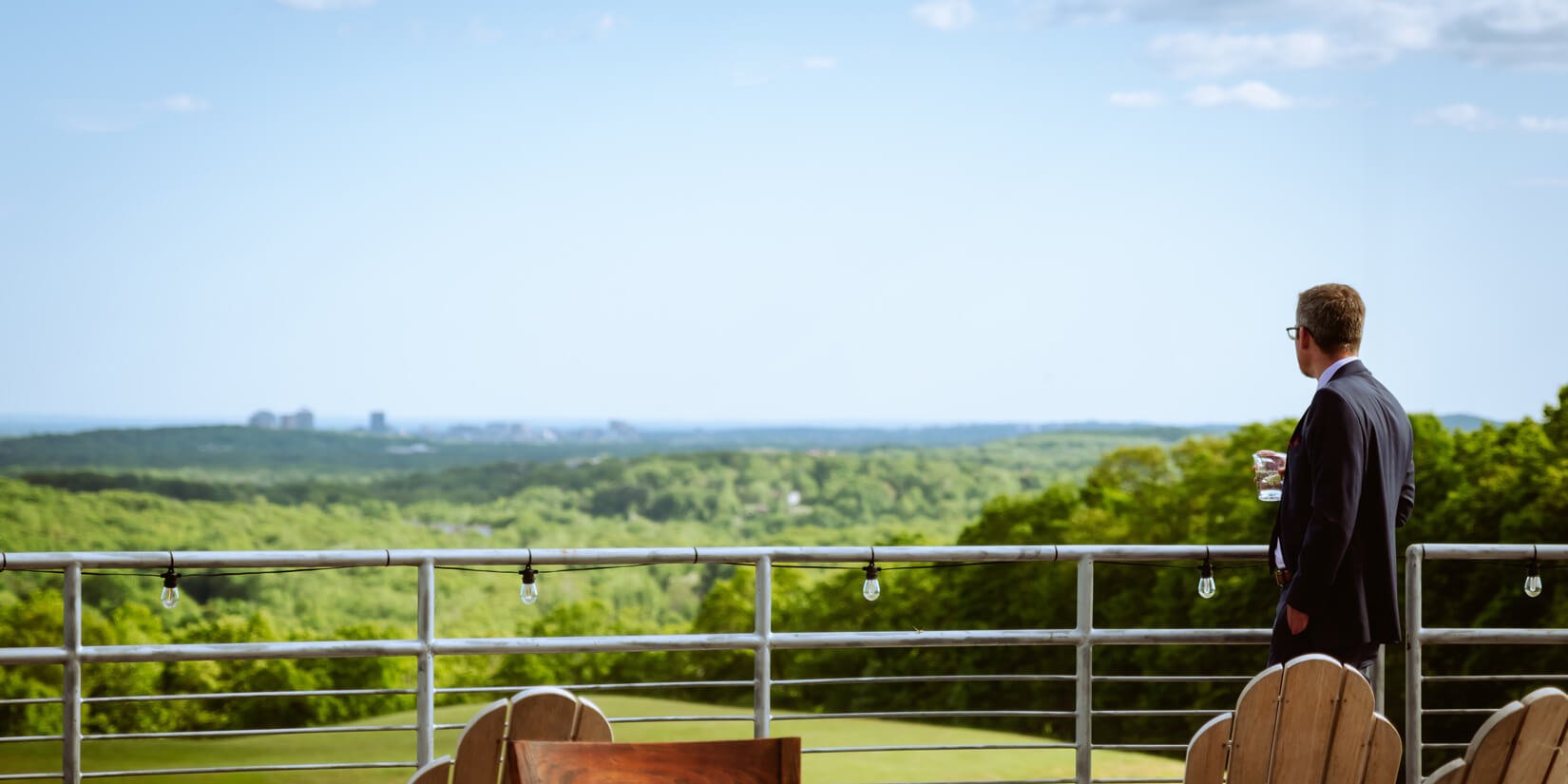 A man soaks up the view from the University Club on Quinnipiac's York Hill Campus